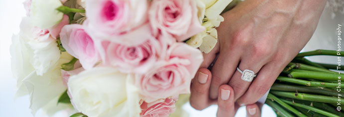Photograph: Close-up of the bride's hands holding a bouquet of pink and white flowers